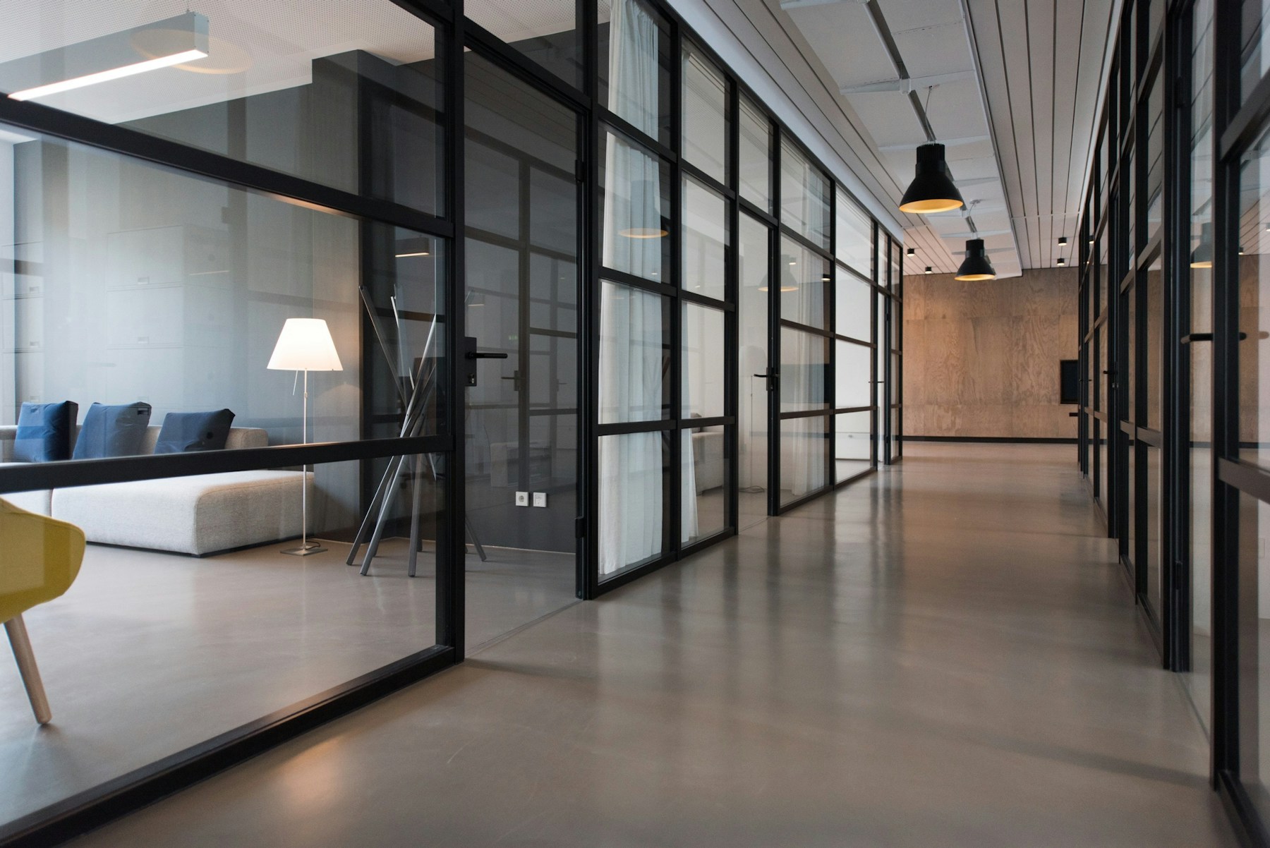 Illustrative photograph of glass-fronted workspaces and a lounge; not this suite.
